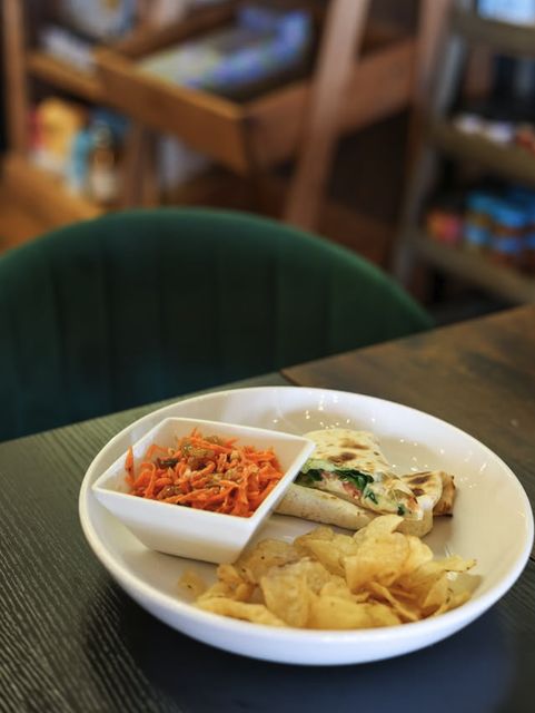 A grilled wrap with carrot slaw and kettle chips